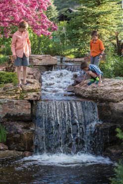 Kids play near a waterfall at Frost Creek