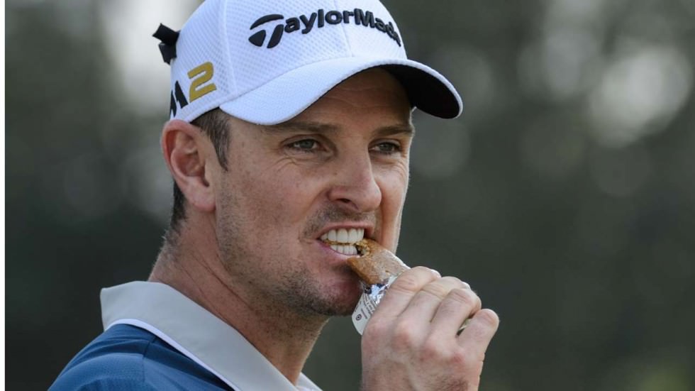 Justin Rose snacks on an energy bar during a round