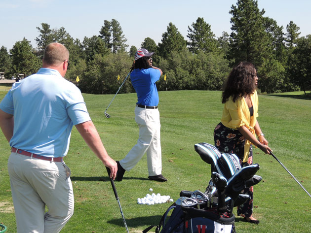 Under the watchful eye of PGA Professional and fellow veteran Cy Twete, Harrison and Brittany take their first swings.