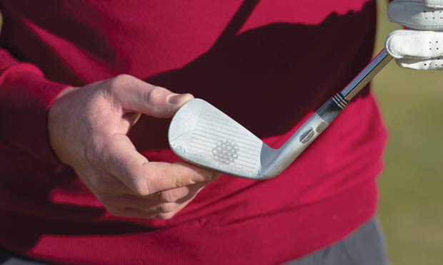 Find the sweet spot: after hitting the golf ball, check where the foot powder has disappeared on the iron to determine impact location.