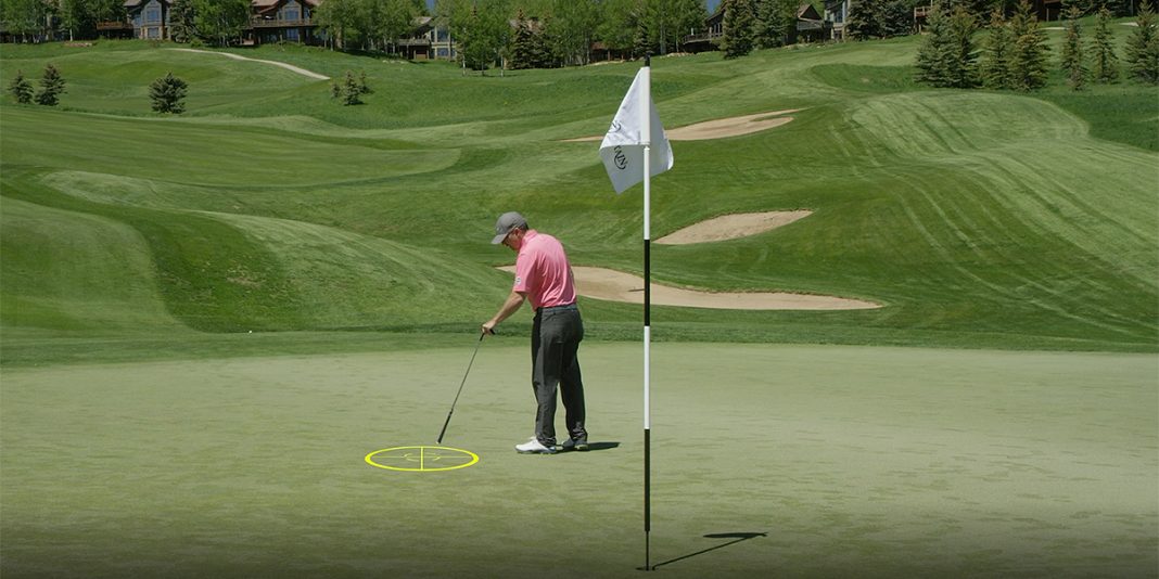 A golfer picks out a landing zone for his approach shot on the green.