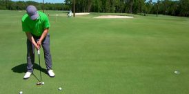 A golfer practices his putting stroke.