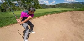 A man prepares to hit a shot out of the bunker