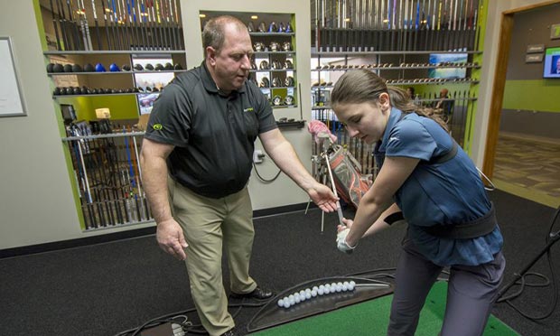 A GOLFTEC coach gives lessons to a beginner