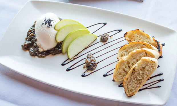 Grilled crostini shares an appetizer plate with Granny Smith slices, a creamy burrata sprinkled with black salt and a pesto-like walnut pistou.