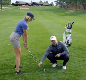 A GOLFTEC instructor teaches a student to hit from the rough