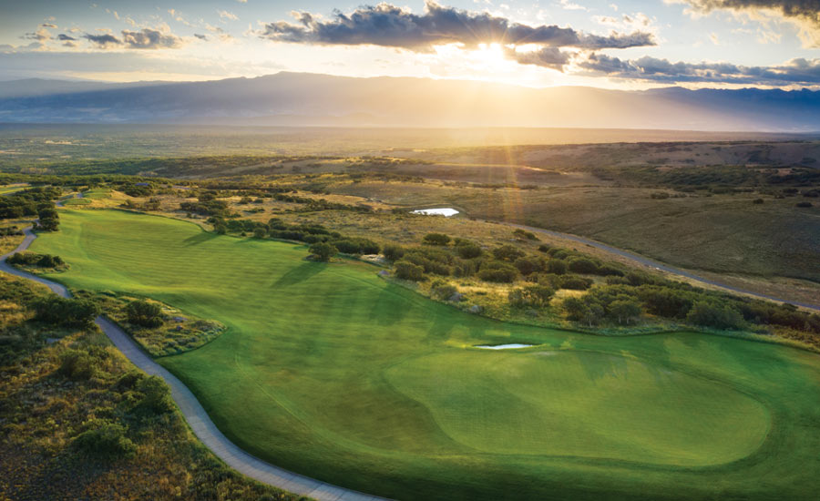 A NEW DAY DAWNS: Rising over the West Elk Mountains, the morning sun butters the 12th green at Cornerstone.