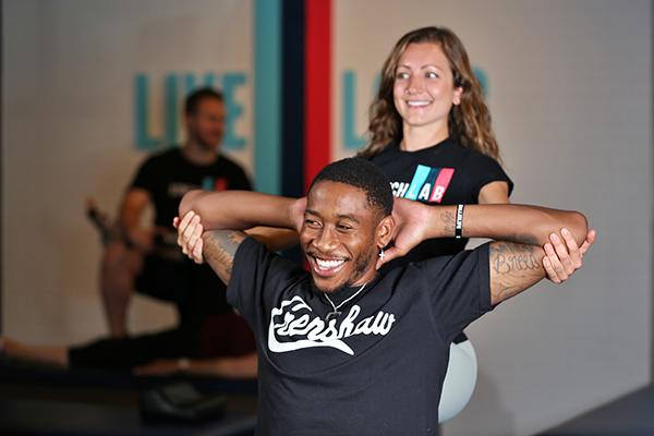 A Stretchlab flexologist stretches a client