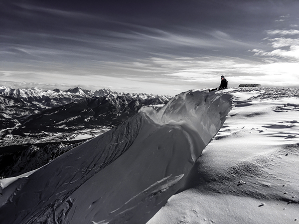 Thad Layton atop a mountain while snowbarding