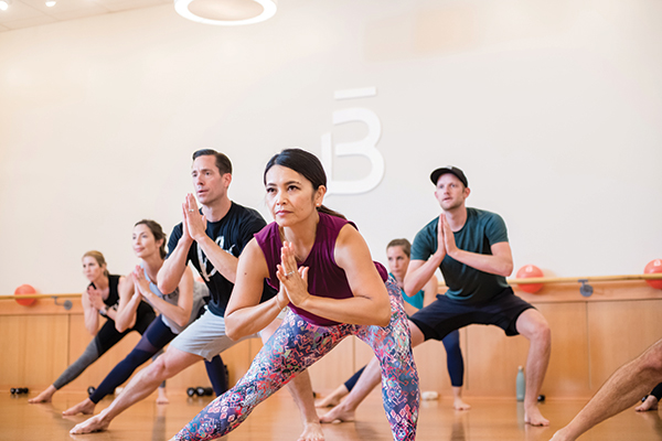 A barre 3 instructor strikes a pose